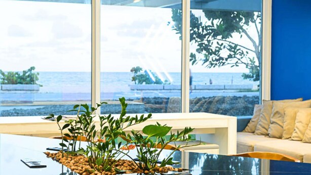 A modern room with large windows, a glass table, and a white sofa. - ibis budget Recife Jaboatão (Jaboatão dos Guararapes)