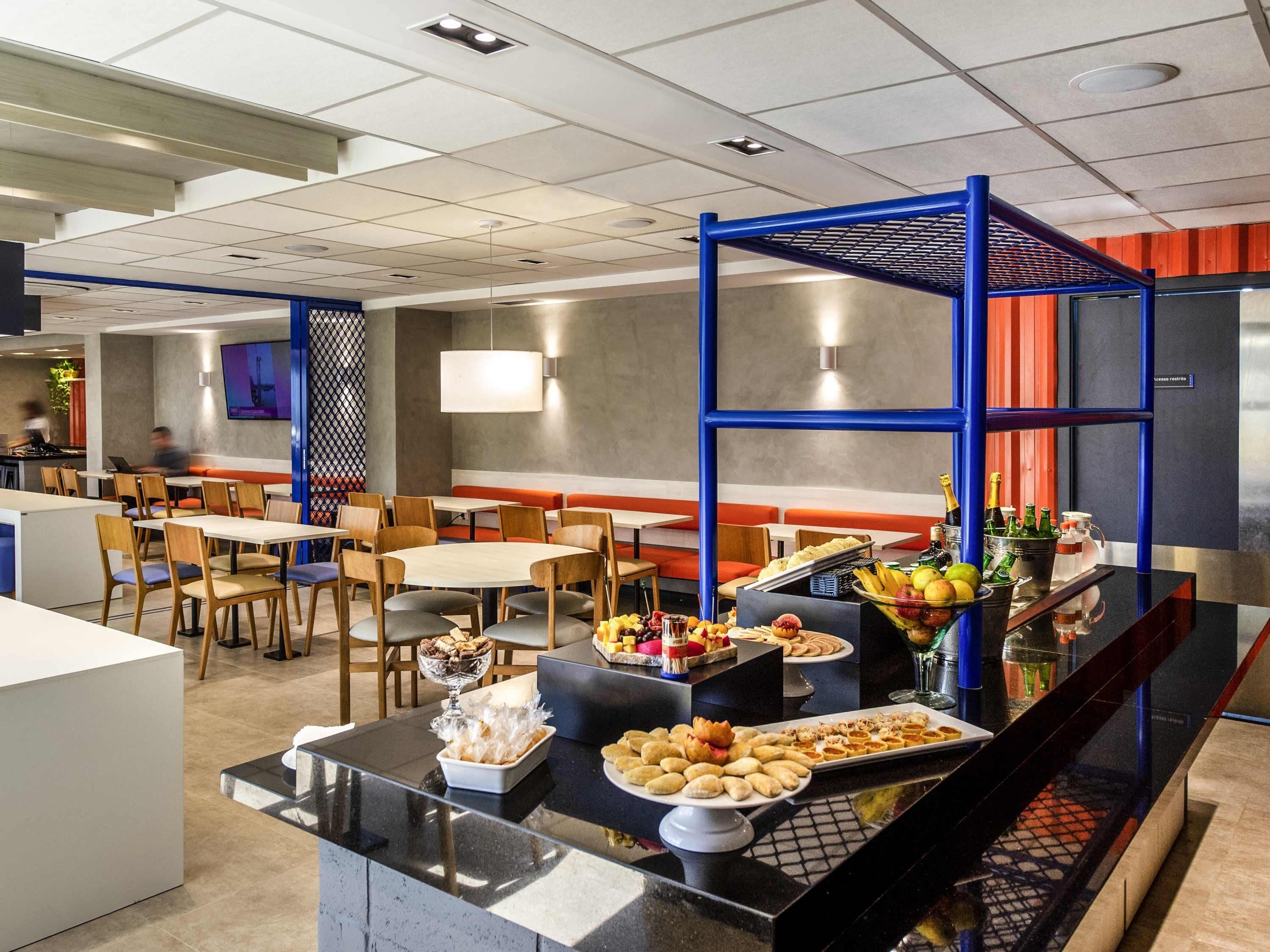 A modern restaurant with a buffet setup, including a variety of food items and beverages.
