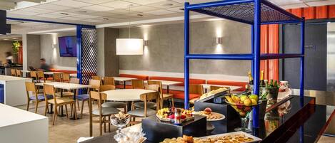 A modern restaurant with a buffet setup, including a variety of food items and beverages.