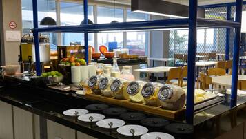 A buffet area with a variety of food items, including fruits, dairy products, and condiments.
