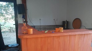 Eine Bar mit Holztresen und Barhocker, eine Kerze und Dekorationselemente.