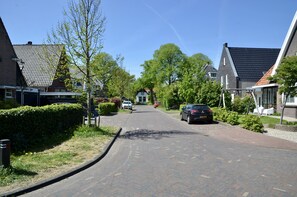 A residential street with houses, parked cars, and a clear sky. - Nice apartment, only 200 m to the center of Bergen and close to the beach! (Bergen)