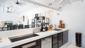 A modern kitchen with a white countertop, stainless steel appliances, and dark cabinetry.