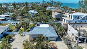 A coastal residential area with houses, a beach, and a clear view of the ocean. - Wave n Sea - Close to the Beach with Pool - Anna Maria Island - By Island Real E (Anna Maria)