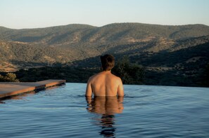 Une personne dans une piscine, avec un paysage montagneux en arrière-plan.