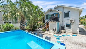 Une maison à deux étages dotée d’une piscine, d’un balcon et d’un patio couvert.