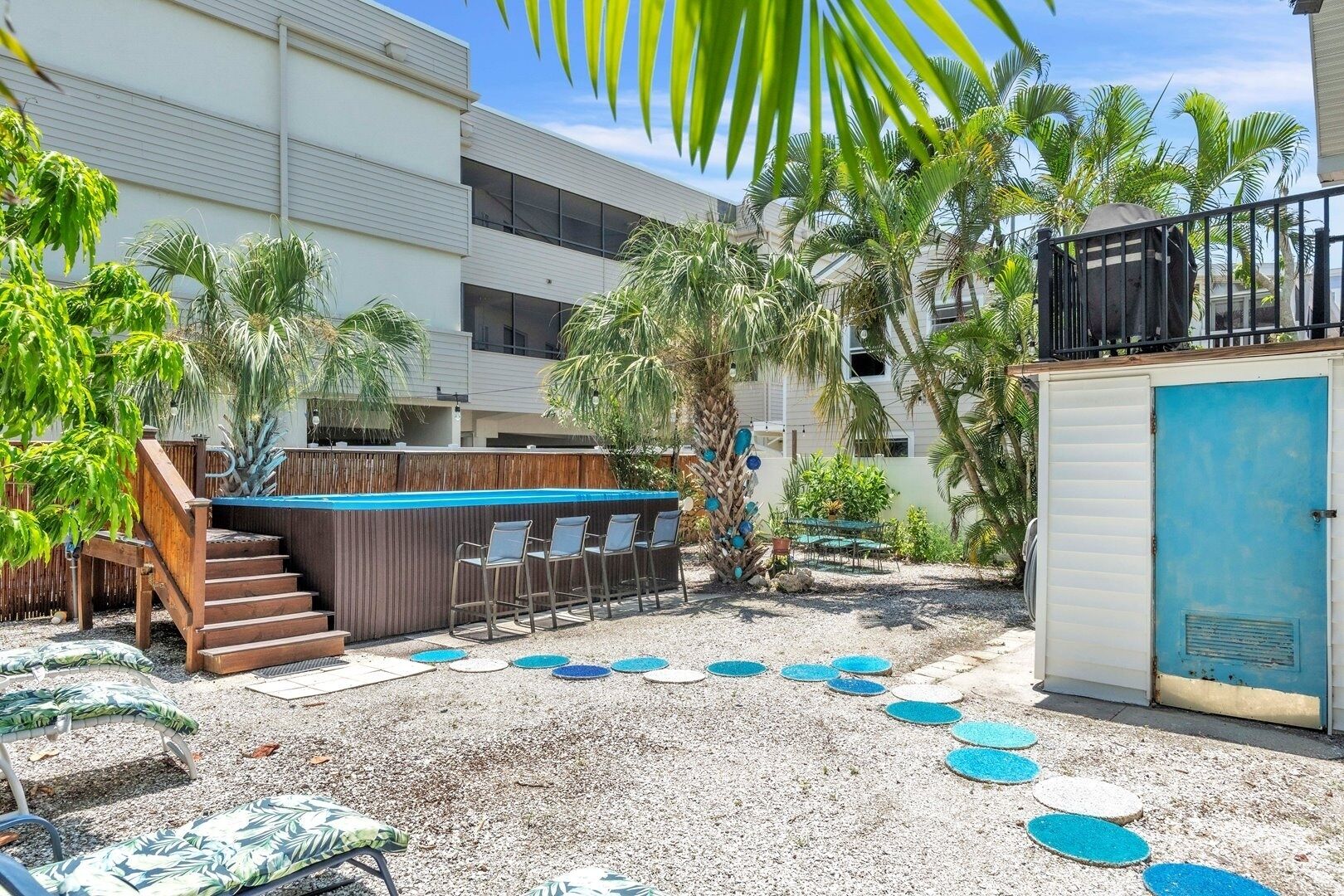 Ein Poolbereich mit Holzterrasse, Liegestühlen und einer kleinen Bar.