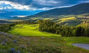 A golf course with a pond, surrounded by forested hills. - No Cleaning Fees, Luxurious 3 Br In River Run Village Featuring Ski In,ski Out 3 Bedroom Condo by RedAwning (Keystone)