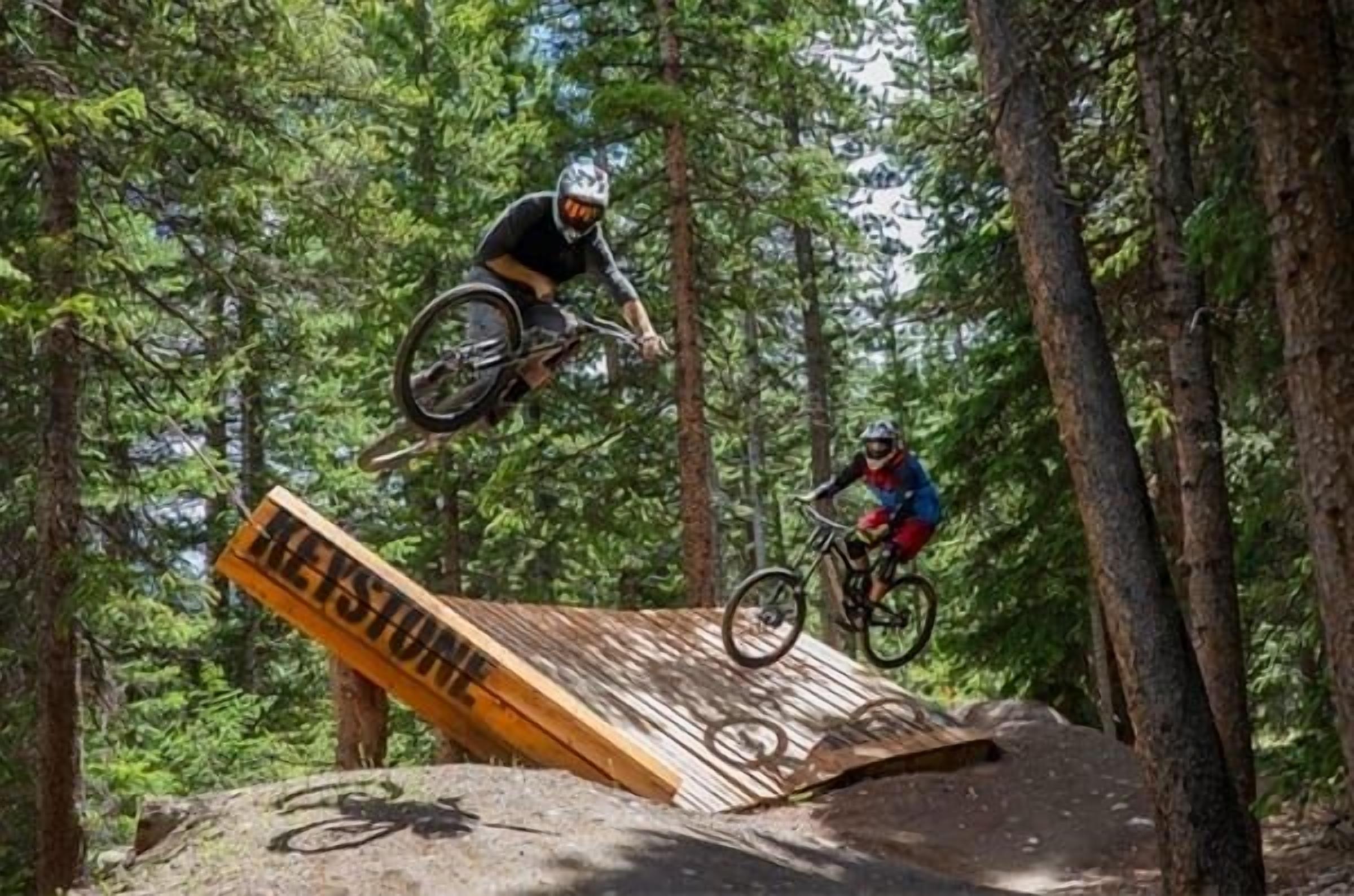 A mountain biking trail with wooden ramps and a sign that reads "TREKSTONE".