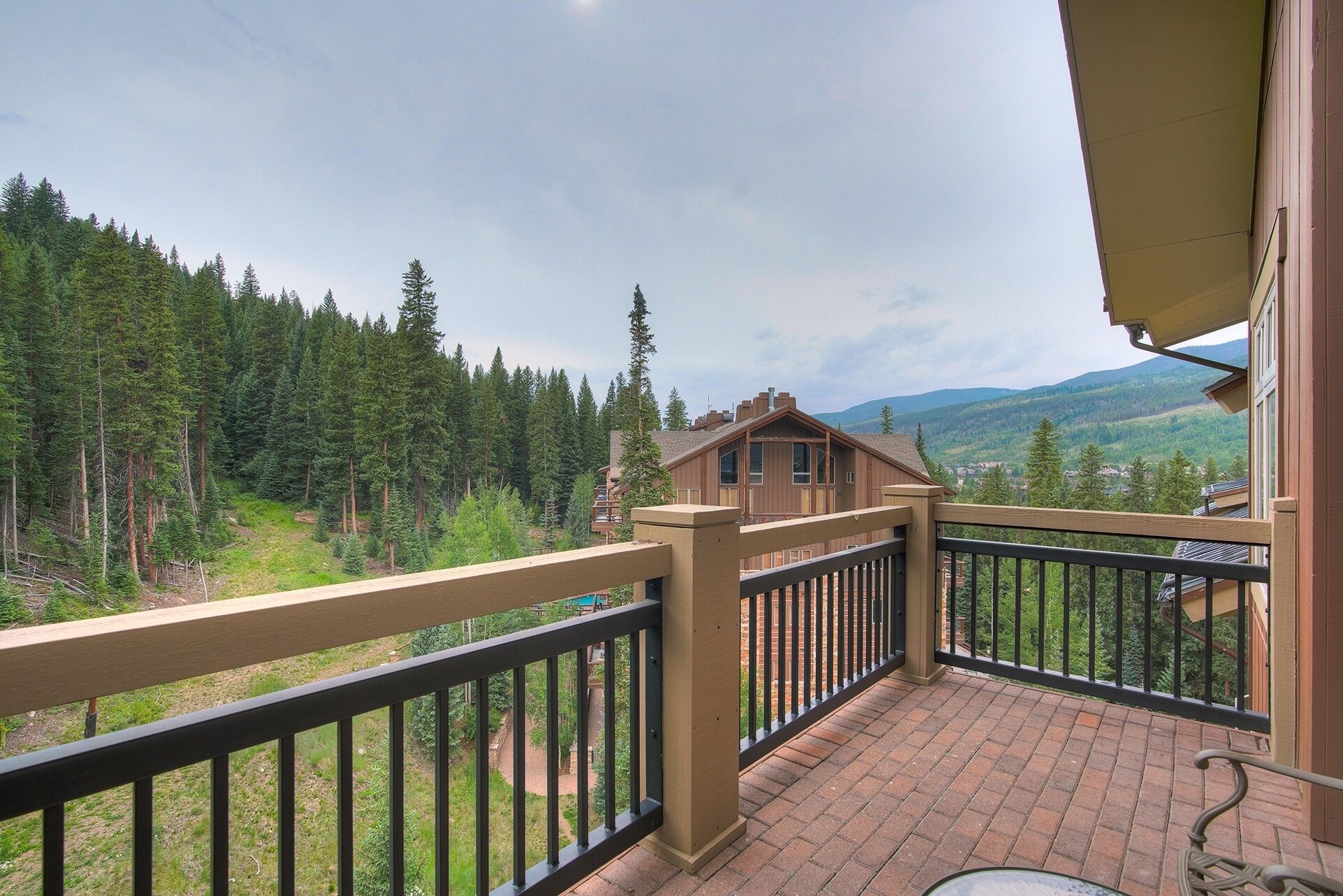 Un balcon avec vue sur une forêt et des montagnes.