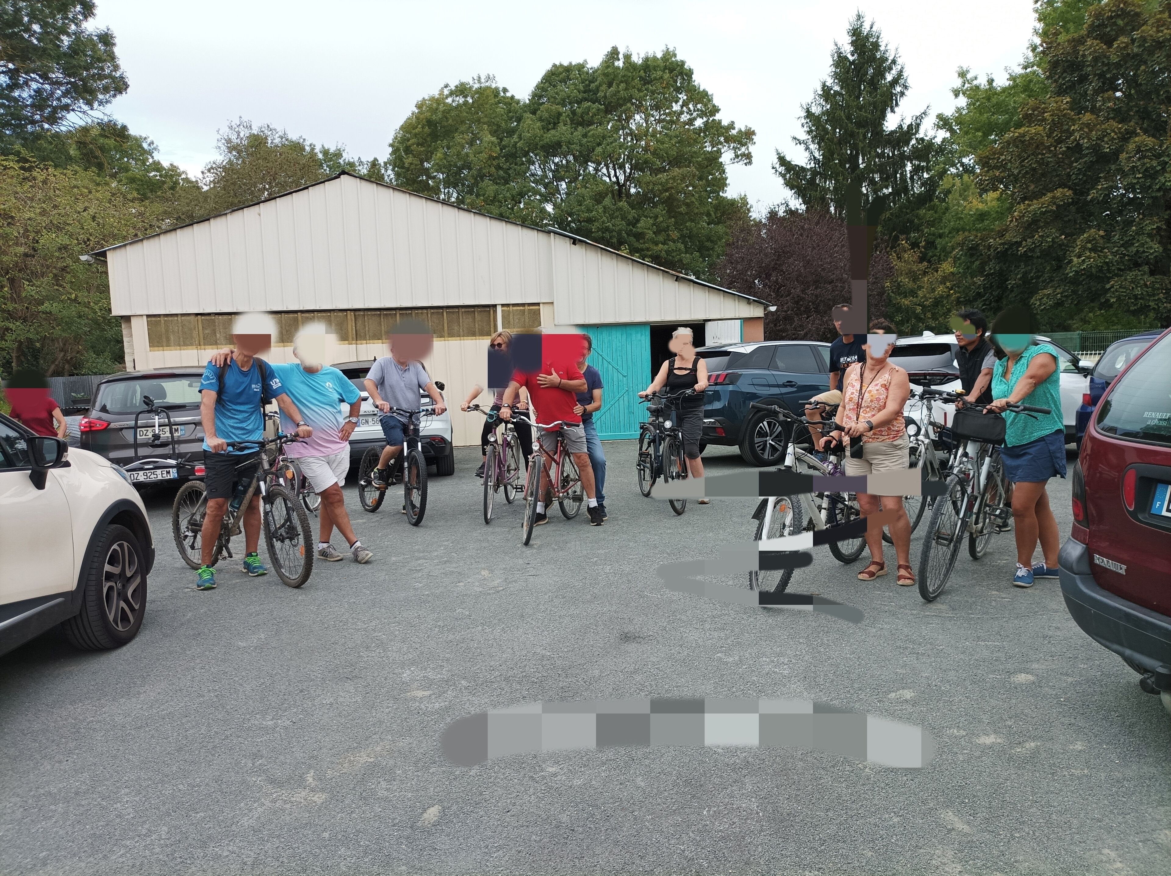 A group of people with bicycles in a parking lot.