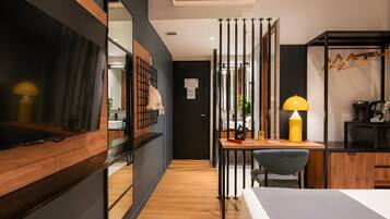 Una habitación de hotel moderna con cama, escritorio, silla y espejo.