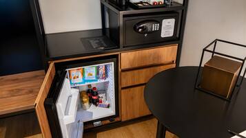 A compact kitchenette with a microwave, coffee maker, and a mini-fridge stocked with snacks.