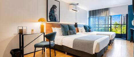 A modern hotel room with two beds, a desk, and a large window.