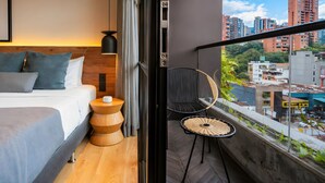 Un dormitorio moderno con cama, mesita de noche y vistas a la ciudad.