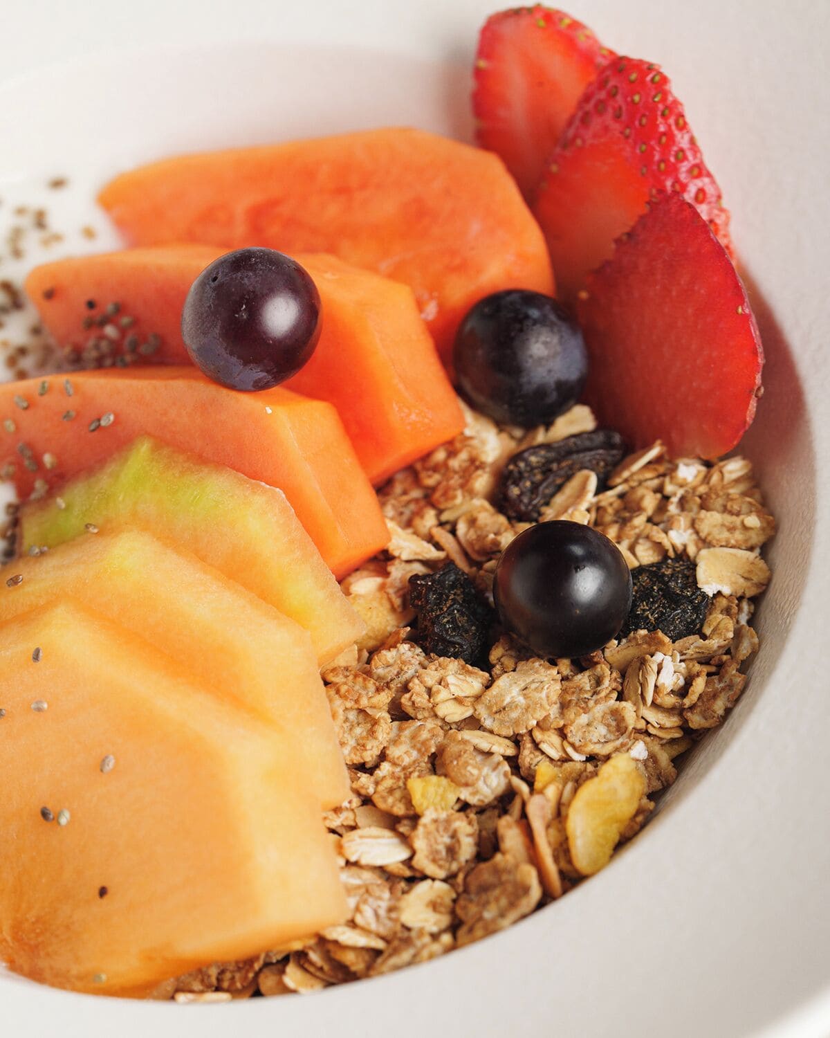 A bowl of granola with mixed fruits and seeds.