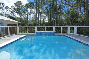 A rectangular swimming pool with a blue tiled edge, surrounded by a wooden deck and a white fence. - Private Pool | Walk to Seaside, WaterColor | 2 Masters- Sonshine by the Sea (Santa Rosa Beach)