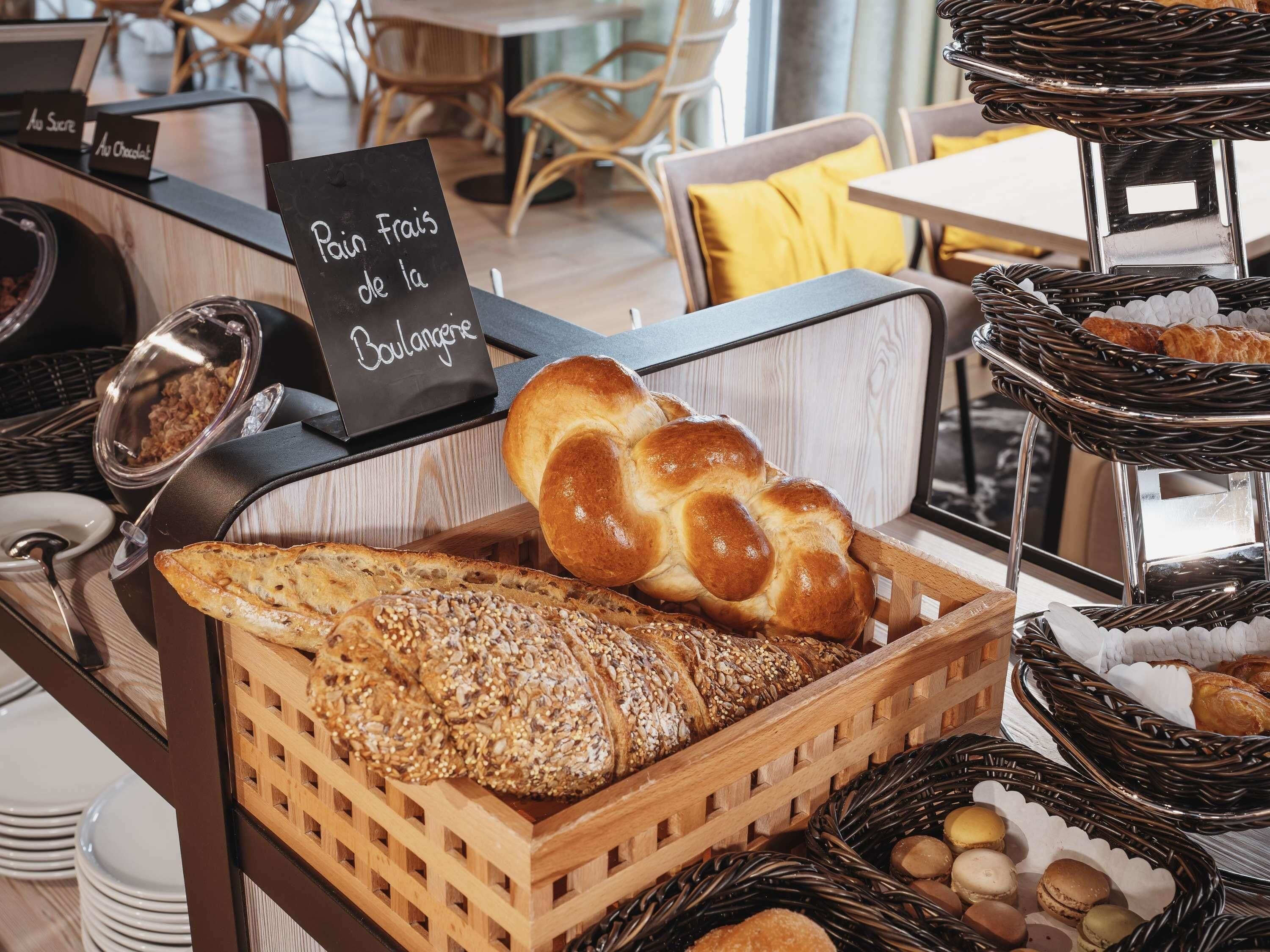 Una vetrina di panetteria con pane, pasticcini e un cartello che indica pane francese della panetteria.