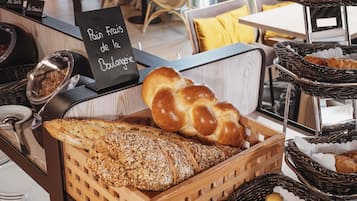 Eine Bäckerauslage mit Brot, Gebäck und einem Schild, das auf französisches Brot aus der Boulangerie hinweist.