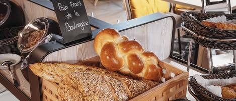 Una vetrina di panetteria con pane, pasticcini e un cartello che indica pane francese della panetteria.