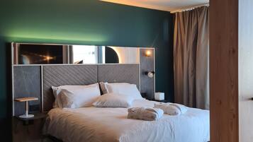 A modern hotel room with a large bed, a bedside table, and a nightstand.