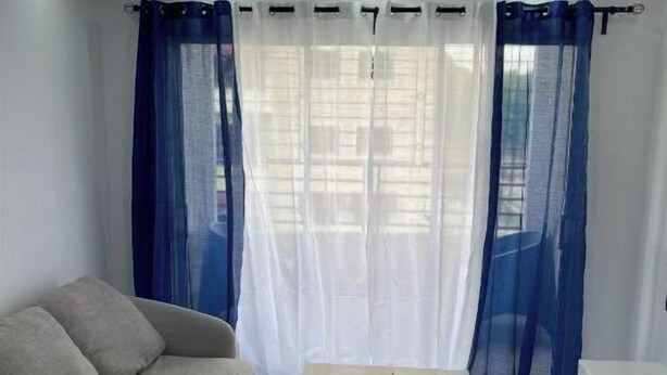 Un salon avec un canapé, une table basse et un ventilateur de plafond.
