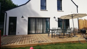 A modern house with a wooden deck, outdoor furniture, and a barbecue grill. - 4 Bedroom Private vacation home in Baden (Baden)