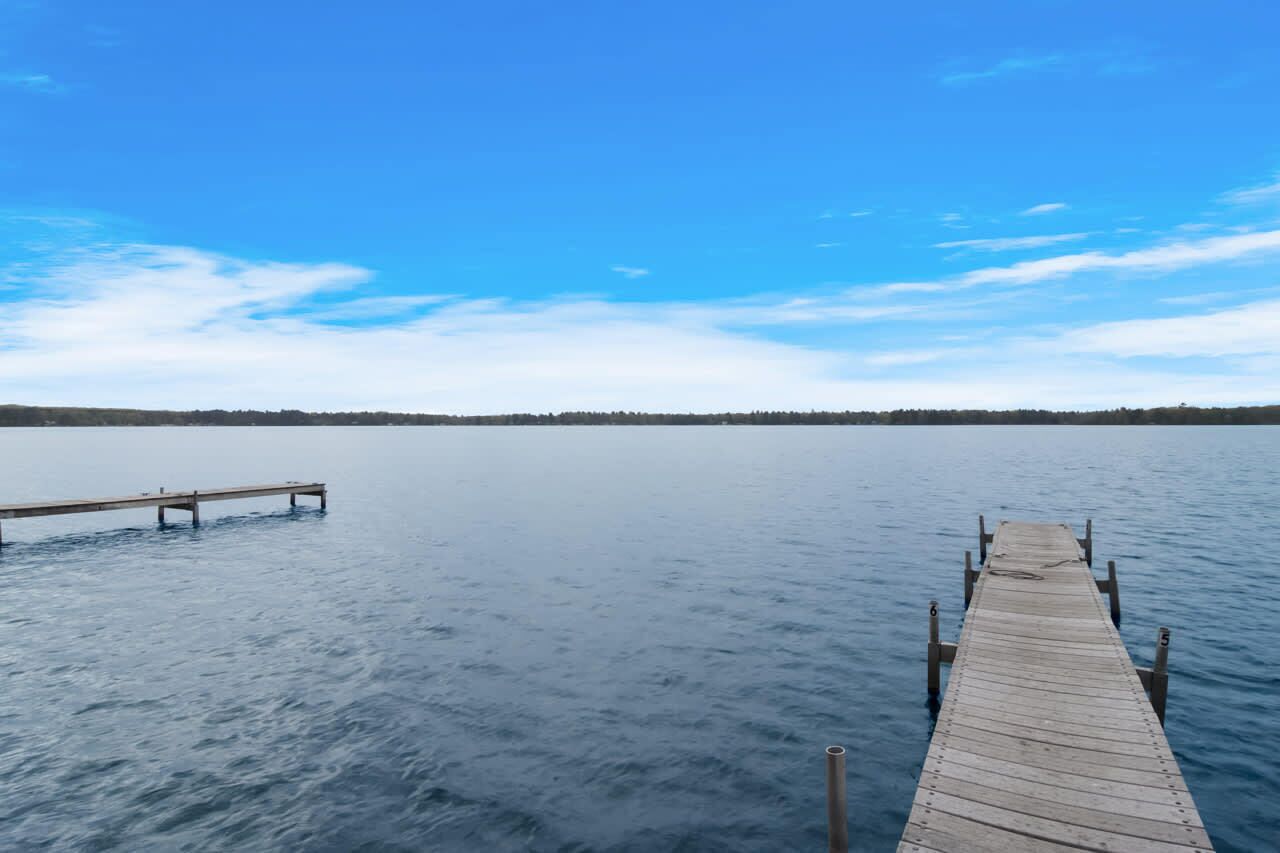 Un muelle de madera que se adentra en aguas tranquilas bajo un cielo despejado.
