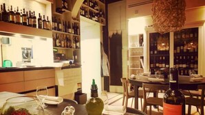A restaurant interior with a bar area, dining tables, and a wine rack.