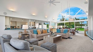 A spacious living room with a large window, a kitchen area, and a dining area.