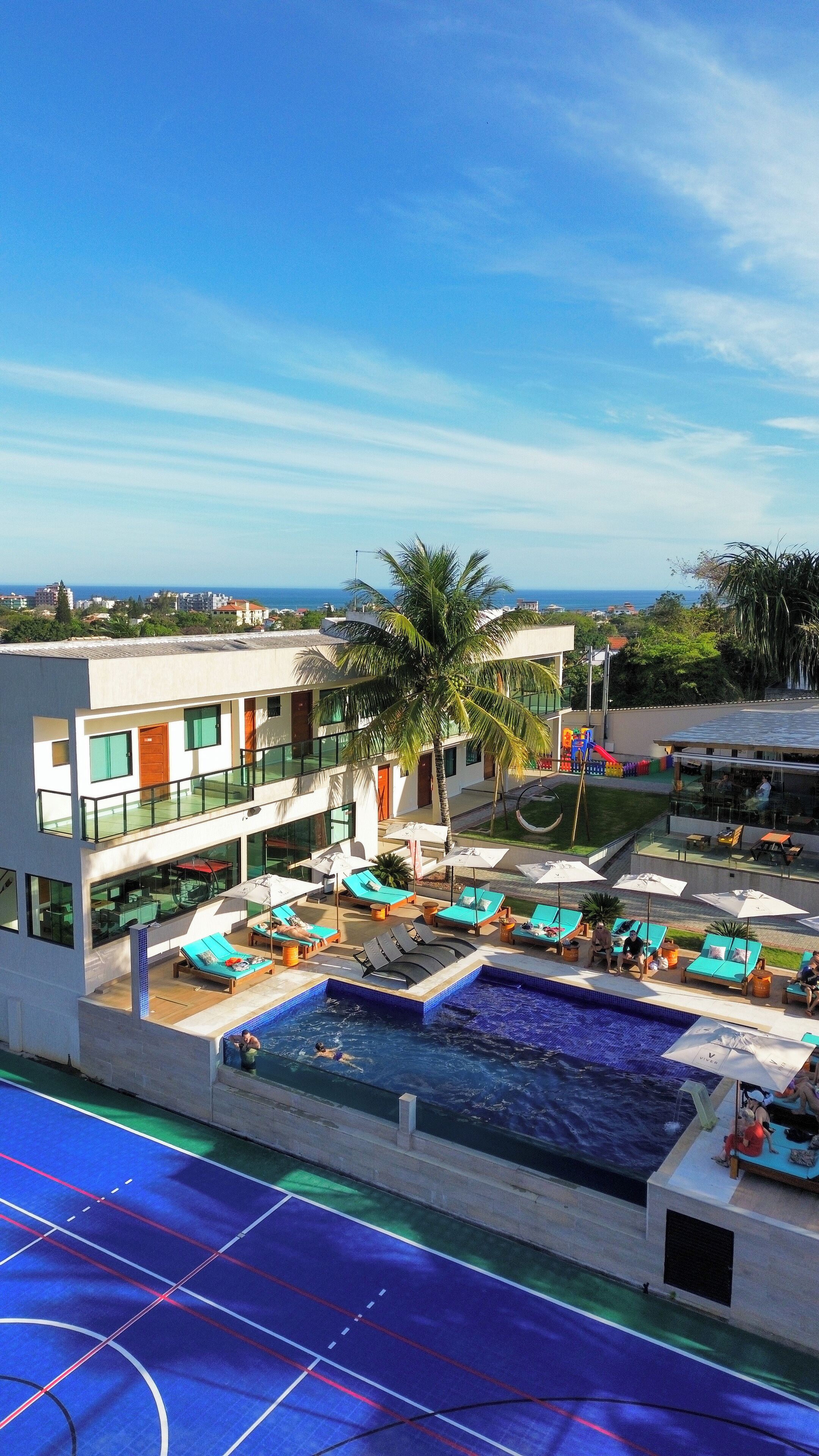 Un hôtel moderne doté d’une piscine, d’un espace extérieur aménagé et offrant une vue sur la mer.