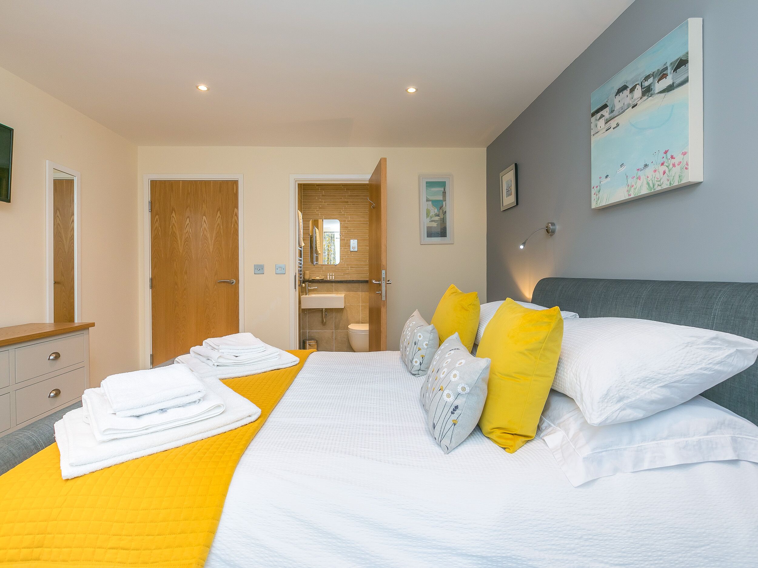 Une chambre d’hôtel moderne dotée d’un grand lit, d’une salle de bain et offrant une vue sur la mer.
