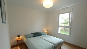 A bedroom with a bed, two bedside tables with lamps, a window, and a wooden floor. - House between Morgat beach (2km) and Crozon town (1km). (Crozon)