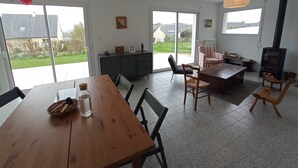 A spacious living room with a wooden dining table, a sofa, and a fireplace. - House between Morgat beach (2km) and Crozon town (1km). (Crozon)