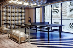 A modern interior with exercise balls, a table, and a patterned floor.