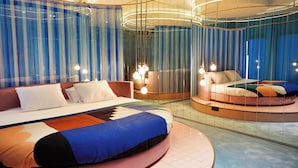 A modern hotel room with a circular bed, a large mirror, and a view of the cityscape. - The Social Hub Madrid 4 star (Madrid)