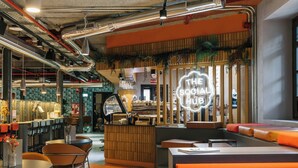 A modern interior with a bar area, seating, and a neon sign. - The Social Hub Madrid 4 star (Madrid)