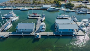 Una marina con varias embarcaciones amarradas en muelles de madera, unidos por pasarelas.