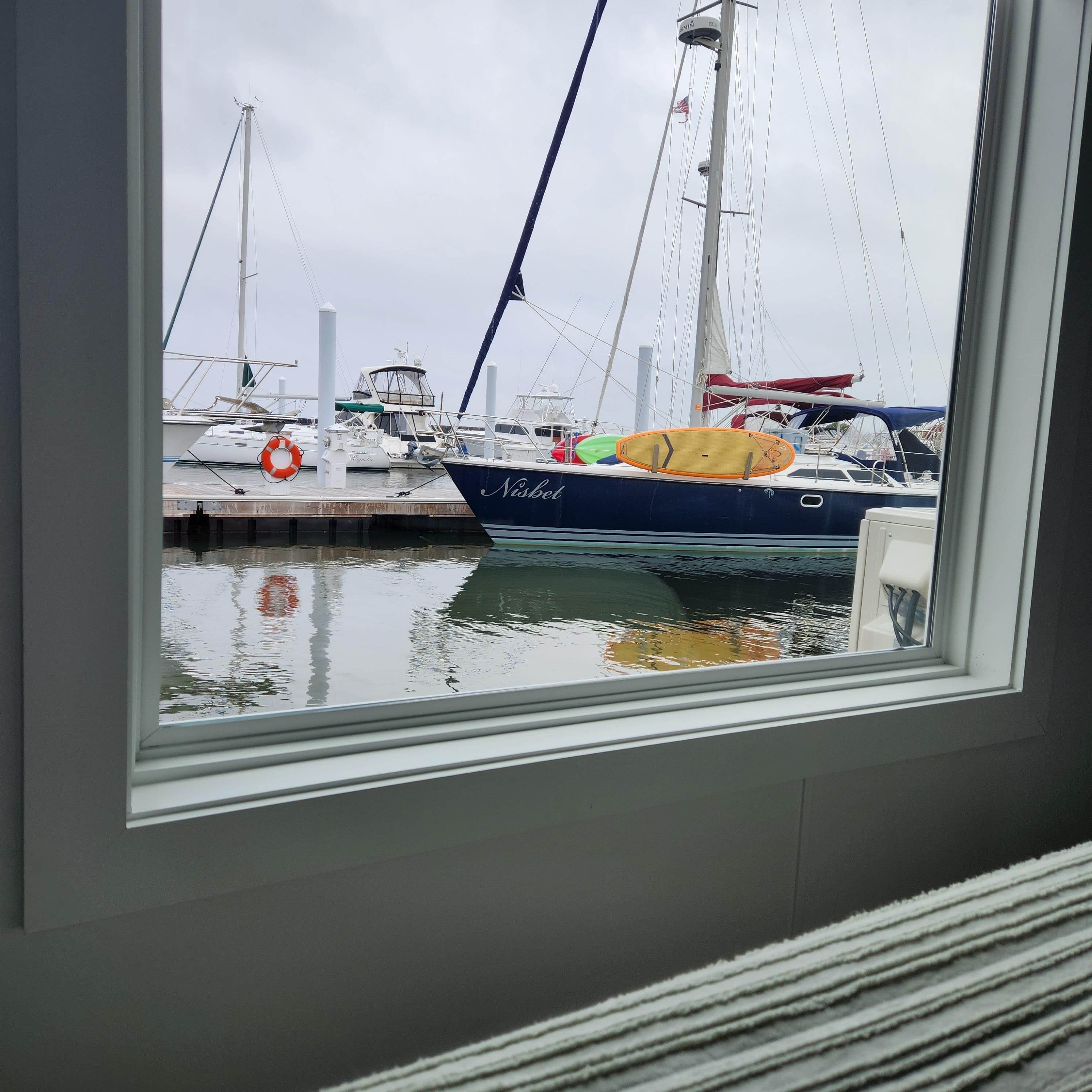 Vista de un puerto deportivo con barcos amarrados, incluyendo un barco llamado 'Nisbet'.
