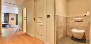 Relax in a spacious room with a large wardrobe, separate bathroom, and cozy seating area.