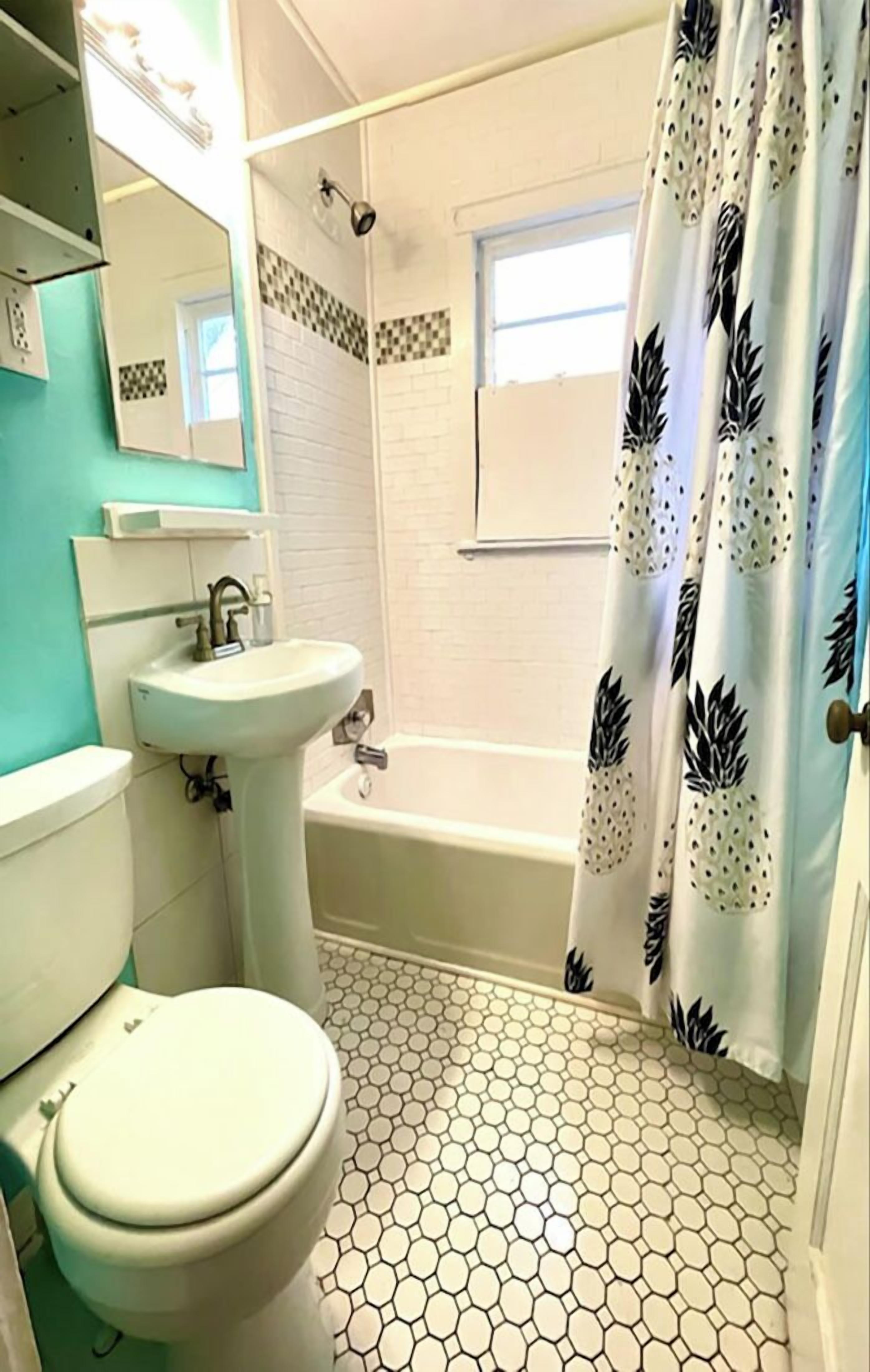 A bathroom with a toilet, sink, and bathtub.