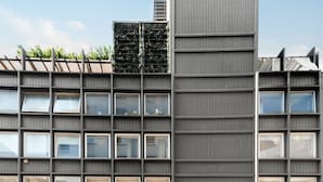 Un edificio moderno caratterizzato da una griglia di finestre e una struttura verticale sulla destra.