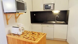 A compact kitchen with a microwave, toaster, and sink. - 50m from resort center, 1st floor, balcony, parking, tv, ski locker, 47m², Les 2 Alpes (Les Deux Alpes)