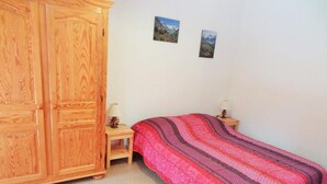 A bedroom with a bed, a wooden wardrobe, a nightstand, and two framed pictures on the wall. - 50m from resort center, 1st floor, balcony, parking, tv, ski locker, 47m², Les 2 Alpes (Les Deux Alpes)