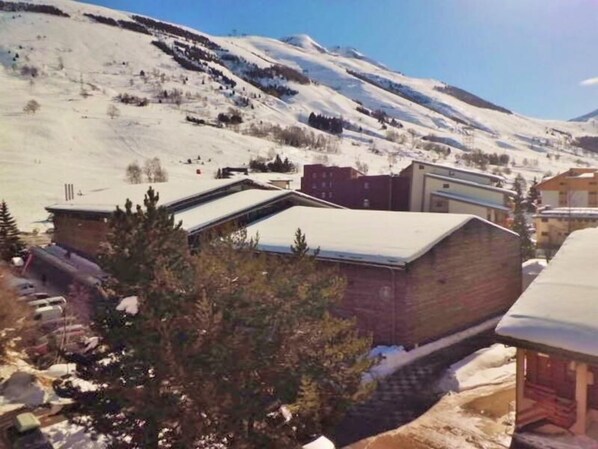 A snow-covered mountain town with buildings and a ski slope.