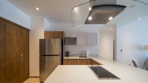 A modern kitchen with a stainless steel refrigerator, a microwave, and a built-in oven. - Icaro - With Rooftop At Ipana Condos (Playa del Carmen)