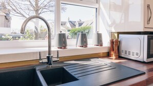 A kitchen with a sink, a window, and a microwave. - Eden Cottage- Quiet City Base (Dundee)