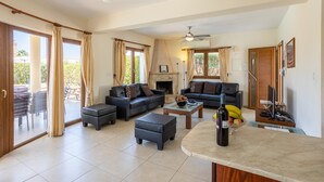 Amplia sala de estar con chimenea, comedor con mesa y sillas, y cocina con mostrador y electrodomésticos.