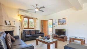 Una sala de estar con un sofá, una mesa de centro de vidrio, un televisor y una chimenea.