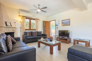 Una sala de estar con un sofá, una mesa de centro de vidrio, un televisor y una chimenea.